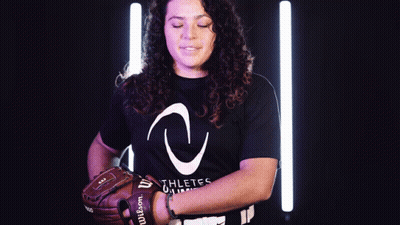 A Woman Wearing A Black Shirt That Says Athletes On It Is Holding A Wilson Baseball Glove GIF