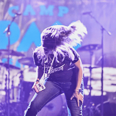 A Woman Wearing A Black Shirt That Says Stomn Is Dancing On Stage GIF