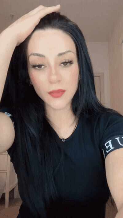 A Woman Wearing A Black Shirt That Says ' Ue ' On The Sleeve GIF
