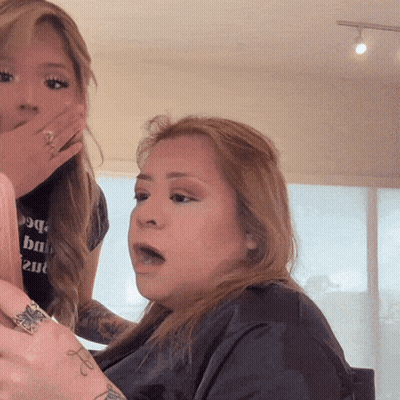 A Woman Wearing A Black Shirt That Says ' Vogue ' On It GIF