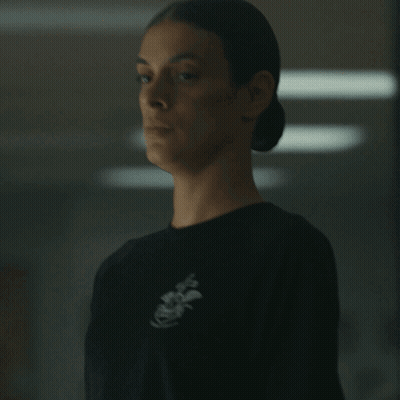 A Woman Wearing A Black Shirt With An Anchor On The Front GIF