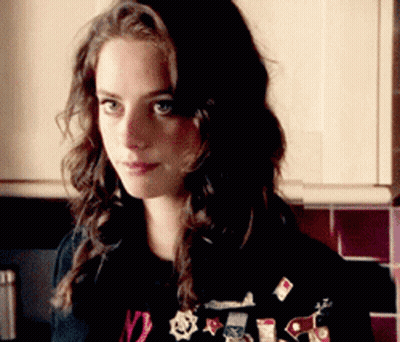 A Woman Wearing A Black Shirt With The Number 12 On It Is Standing In A Kitchen GIF