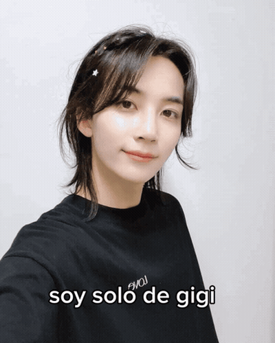 A Woman Wearing A Black Shirt With The Words Soy Solo De Gigi On The Front GIF