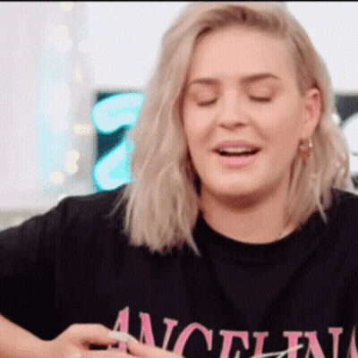 A Woman Wearing A Black T-Shirt That Says " Angel " On It GIF