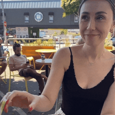 A Woman Wearing A Black Tank Top With The Letter M On Her Chest GIF