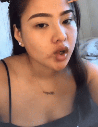 A Woman Wearing A Black Top And A Necklace That Says ' L' Amour ' On It GIF