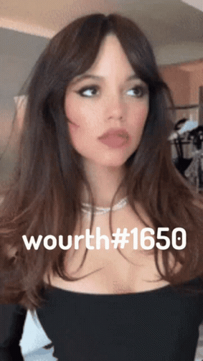 A Woman Wearing A Black Top And A Necklace With The Number 1650 On Her Chest GIF