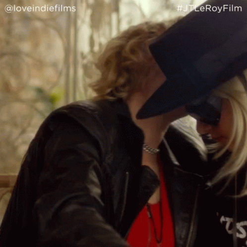 A Woman Wearing A Black Top Hat And A Leather Jacket With The Hashtag #Jtleroyfilm On The Bottom GIF