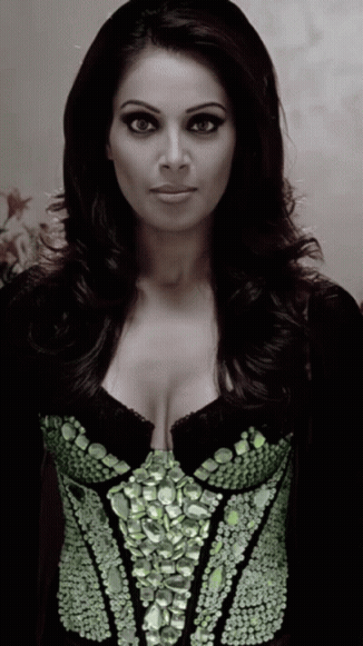 A Woman Wearing A Black Top With Green Rhinestones GIF