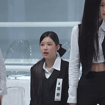 A Woman Wearing A Black Vest With The Number 8 On The Front GIF