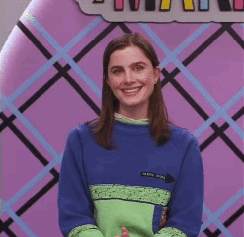 A Woman Wearing A Blue And Green Sweater With The Word Tropic Written On It GIF