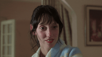 A Woman Wearing A Blue And White Striped Robe Smiles At The Camera GIF