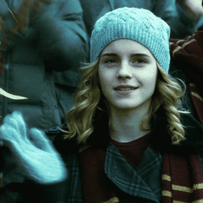 A Woman Wearing A Blue Beanie And Gloves Looks At The Camera GIF