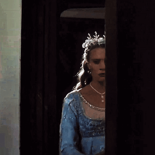 A Woman Wearing A Blue Dress And A Silver Tiara GIF