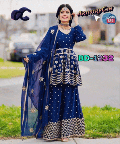 A Woman Wearing A Blue Dress With Gold Embroidery Is Standing On The Sidewalk GIF