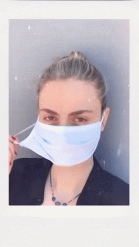 A Woman Wearing A Blue Face Mask With A Bun GIF