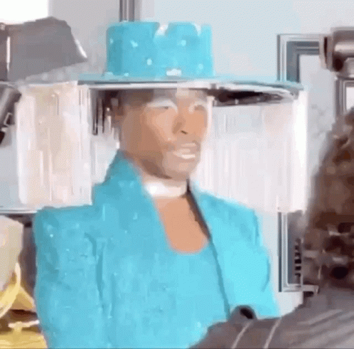 A Woman Wearing A Blue Hat And A Blue Jacket Is Talking To A Man . GIF