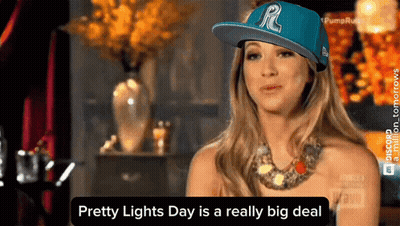 A Woman Wearing A Blue Hat With The Letter R On It Says Pretty Lights Day Is A Really Big Deal GIF