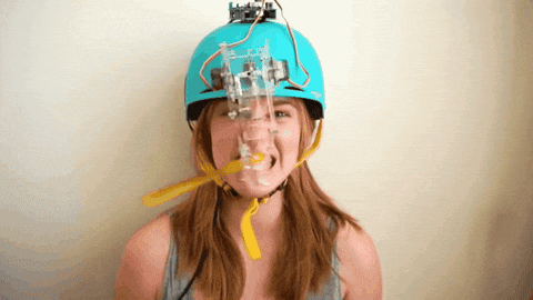 A Woman Wearing A Blue Helmet With A Robotic Device On It GIF