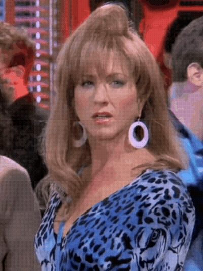 A Woman Wearing A Blue Leopard Print Dress And White Earrings Is Standing In A Crowd . GIF