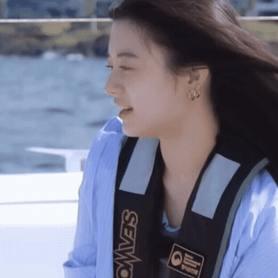 A Woman Wearing A Blue Shirt And A Black Vest That Says Seavest GIF