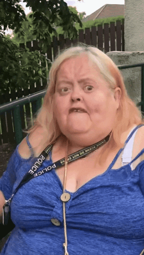 A Woman Wearing A Blue Shirt And A Police Lanyard GIF