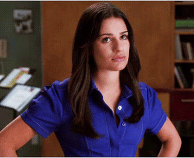 A Woman Wearing A Blue Shirt Is Standing With Her Hands On Her Hips GIF