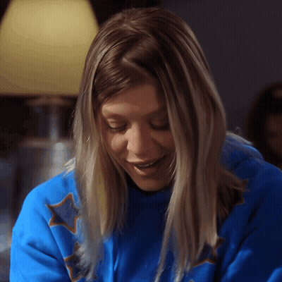 A Woman Wearing A Blue Shirt With Stars On It GIF