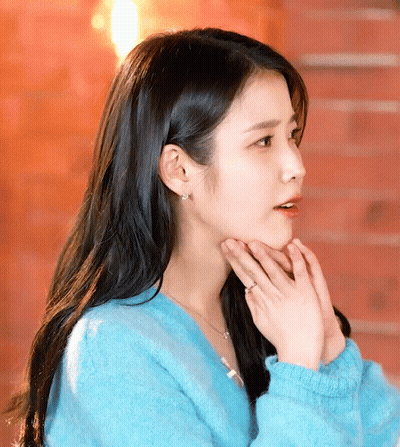 A Woman Wearing A Blue Sweater And A Ring On Her Finger GIF