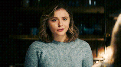 A Woman Wearing A Blue Sweater Looks At The Camera GIF