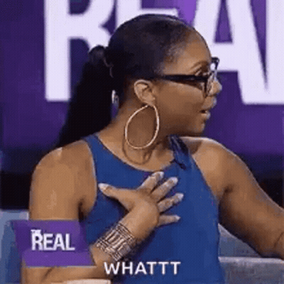A Woman Wearing A Blue Tank Top And Hoop Earrings Is Holding Her Chest . GIF