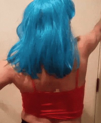 A Woman Wearing A Blue Wig And A Red Tank Top Is Dancing . GIF