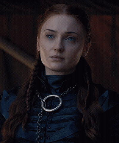 A Woman Wearing A Braided Ponytail And A Chain Around Her Neck . GIF