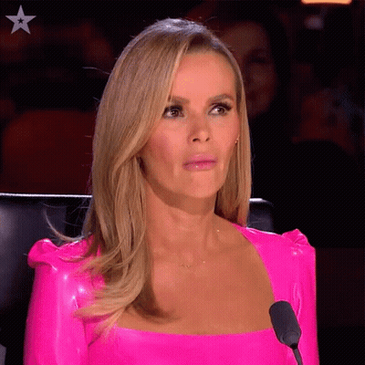 A Woman Wearing A Bright Pink Top Is Sitting In Front Of A Microphone GIF