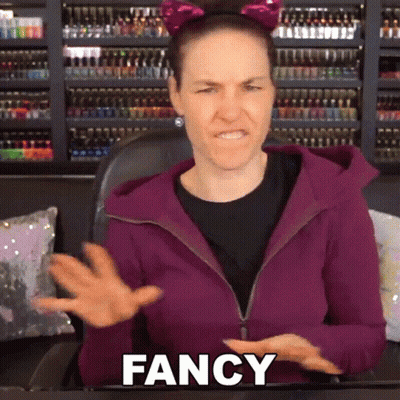 A Woman Wearing A Cat Ear Headband And A Purple Jacket Is Saying Fancy GIF