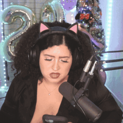 A Woman Wearing A Cat Ear Headband Looks At Her Phone GIF