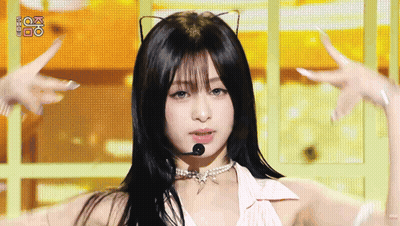 A Woman Wearing A Cat Ear Necklace And A Microphone On Stage . GIF