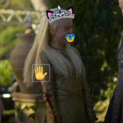 A Woman Wearing A Cat Ear Tiara With A Pacifier In Her Mouth . GIF