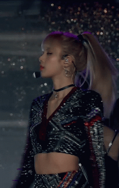 A Woman Wearing A Choker And A Crop Top Is Standing In Front Of A Microphone GIF