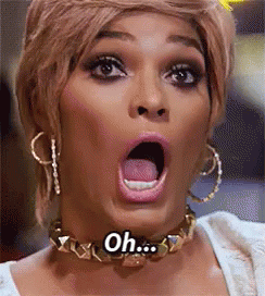A Woman Wearing A Choker And Hoop Earrings Is Making A Surprised Face With Her Mouth Open . GIF