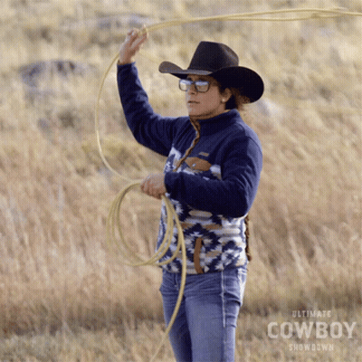 A Woman Wearing A Cowboy Hat And Sunglasses Is Holding A Lasso In A Field GIF