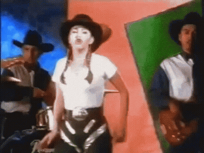 A Woman Wearing A Cowboy Hat Is Dancing With Two Men GIF
