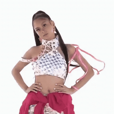 A Woman Wearing A Crop Top And A Pink Skirt Is Standing With Her Hands On Her Hips . GIF