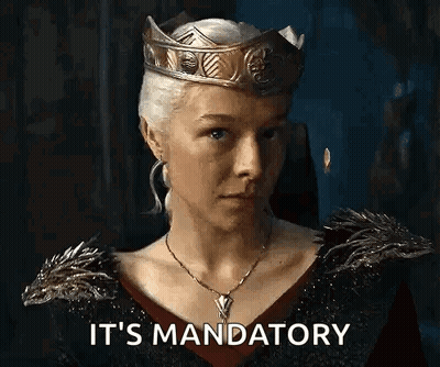 A Woman Wearing A Crown And A Necklace Is Saying `` It 'S Mandatory '' In A Dark Room . GIF