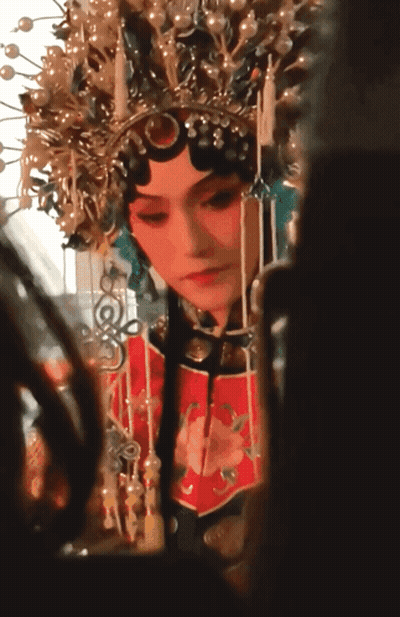 A Woman Wearing A Crown And A Red Dress Looks At Herself In A Mirror GIF