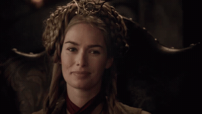 A Woman Wearing A Crown And A Red Scarf Is Smiling GIF