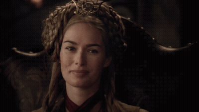 A Woman Wearing A Crown And A Red Scarf Is Smiling GIF