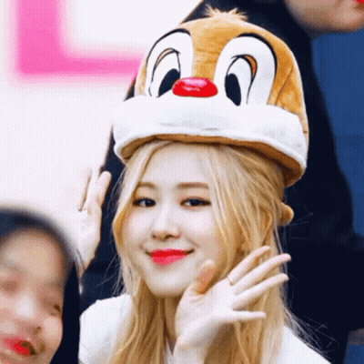 A Woman Wearing A Dale The Squirrel Hat Waves At The Camera GIF