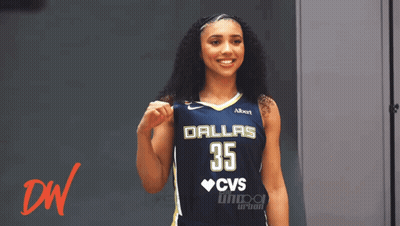 A Woman Wearing A Dallas 35 Jersey Holds Her Fist Up GIF