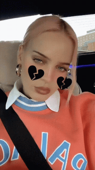 A Woman Wearing A Dallas Sweatshirt Is Sitting In The Back Seat Of A Car GIF